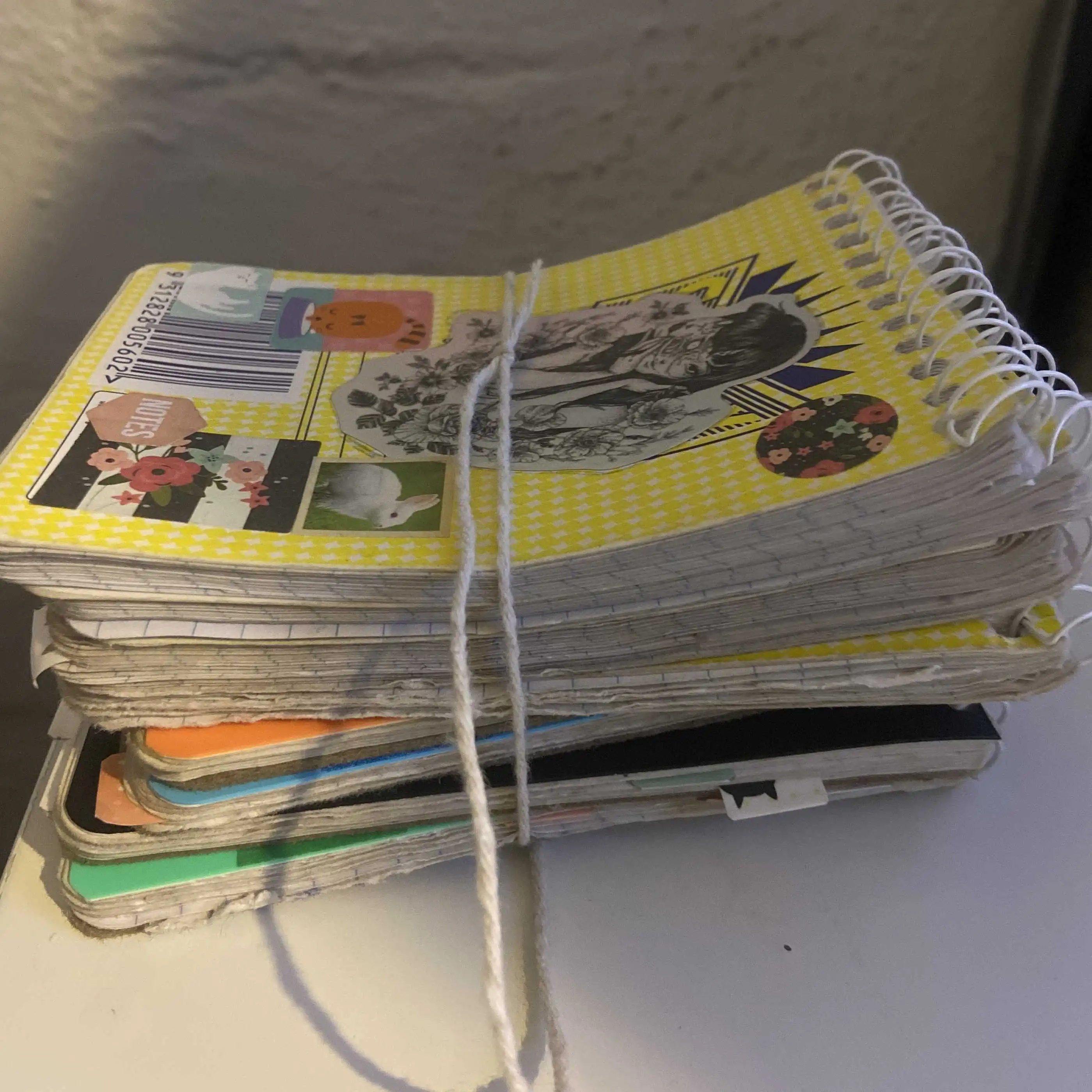 a picture of the notebooks in the previous picture stacked on top of eachother and tied together with string